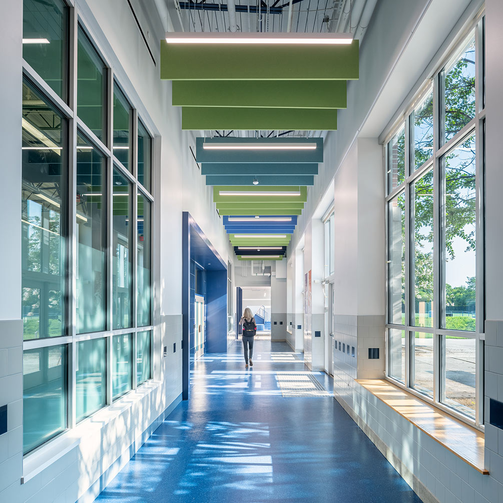 A sunlit hallway with blue floors and green and blue accents.